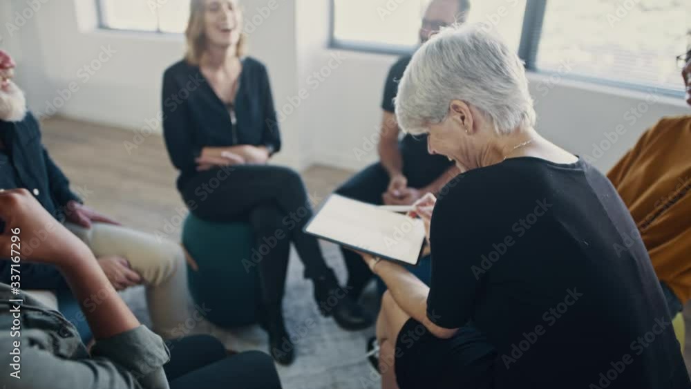 Group of corporate professionals laughing during team building training session in the office. Coach using a digital tablet with the multi-ethnic business team sitting in a circle.
Group of corporate professionals laughing during team building training session in the office. Coach using a digital tablet with the multi-ethnic business team sitting in a circle.