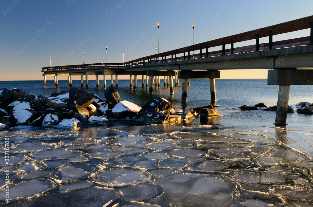 Lake Ontario blue sky sunset at Toronto Center Island Pier in winter with ice flow tiles