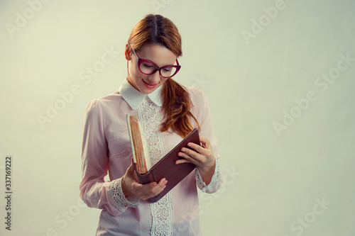 A young pretty woman between 30 and 40 years old with an old book photo