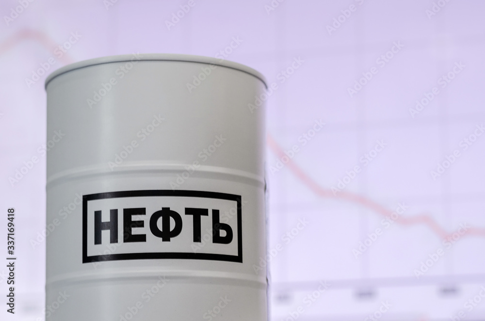 Falling oil prices. Barrel with the words oil in Russian, located on the background of a graph of falling prices. Oil crisis. Selective focus. Falling oil prices. Barrel with the words oil in Russian, located on the background of a graph of falling prices. Oil crisis. Selective focus.