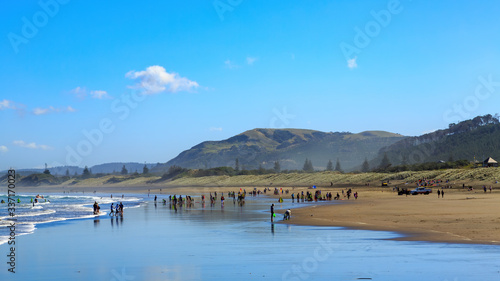 Fototapeta Naklejka Na Ścianę i Meble -  Panoramic view of the black sand beach at Muriwai, New Zealand, on a sunny day