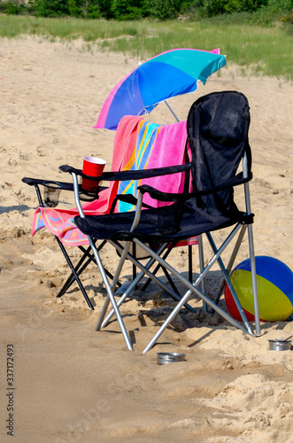 Beach chair , umbrella and ball  on a sandy beach on a sunny vacation holiday
