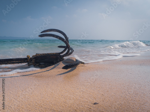 An anchor of a boat lying on the Govind Nagar beach in the Andamans, India. Creative low angle shot.