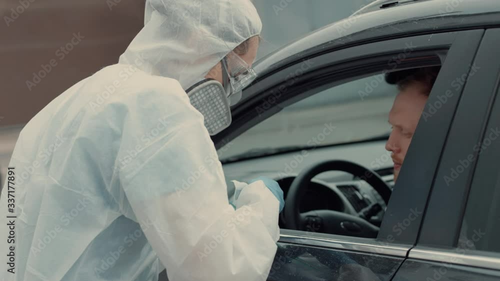 Patient is being tested in his vehicle on a drive-through coronavirus COVID-19 testing location. Pandemic, infection Patient is being tested in his vehicle on a drive-through coronavirus COVID-19 testing location. Pandemic, infection
