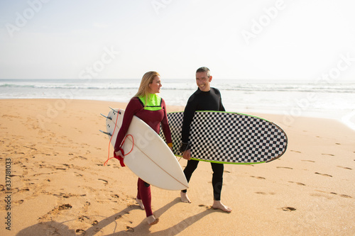 Photography Happy surfers going away from beach and talking