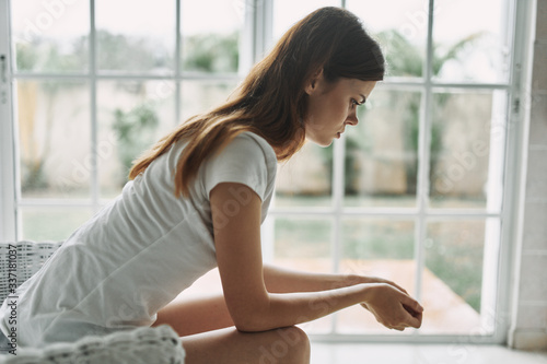 young woman sitting on window sill Free Download young woman sitting on window sill - GFXLoad