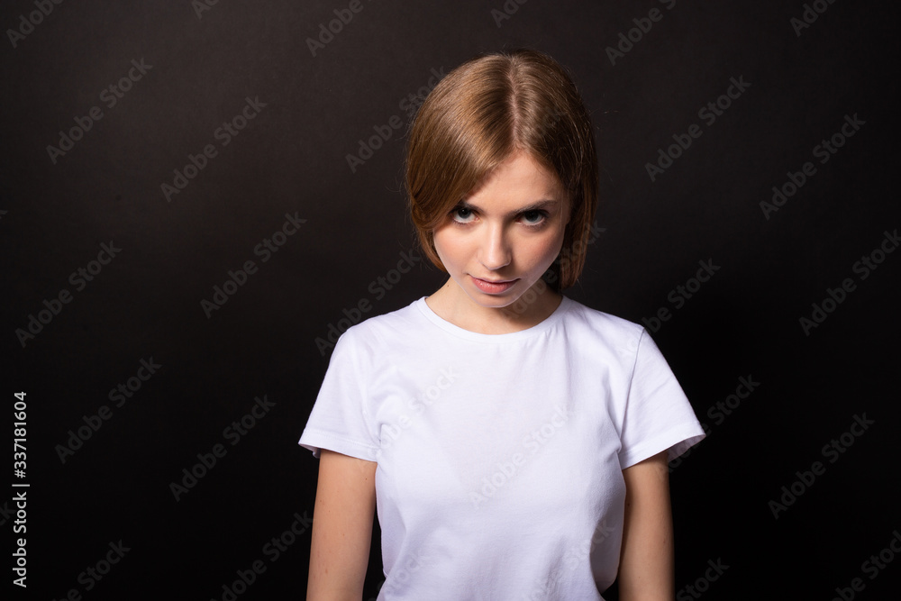 Girl looking from under the forehead conceived something bad. Black background Girl looking from under the forehead conceived something bad. Black background