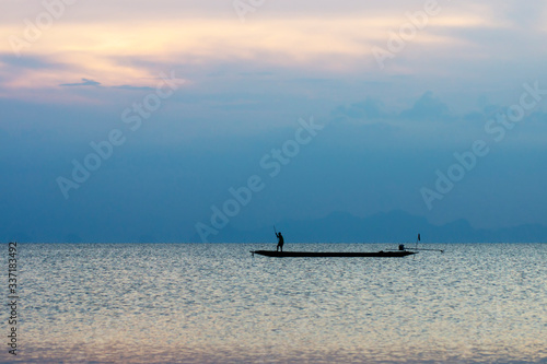 Minimal silhouette fishermans on the lake with twilight sky.