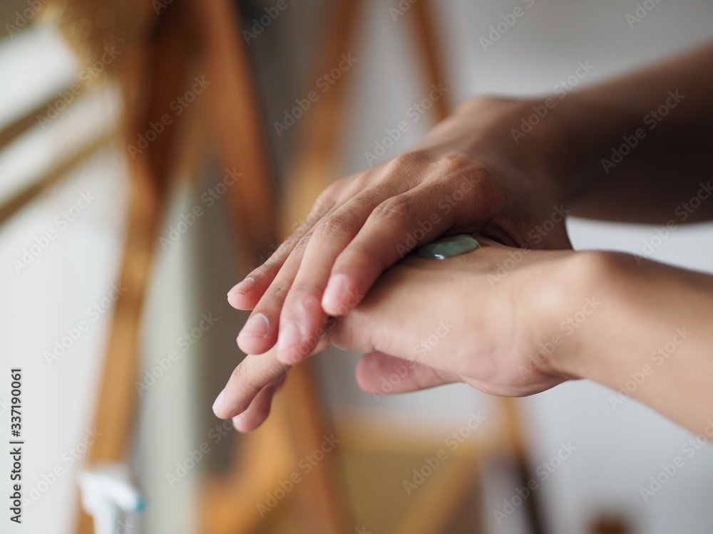 Obraz premium dziecko stoi palcem, aby pocierać żelem 70-procentową mieszankę alkoholową z żelatyną na grzbiecie dłoni, aby zapobiec zarazkom, chronić przed wirusem koronowym, covid19, odkażacz do rąk