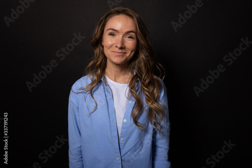 Attractive woman looks at camera with smile. Isolated on black background