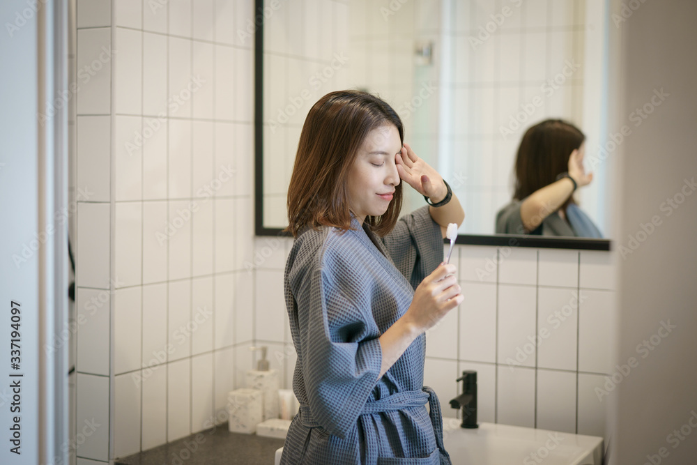Woman brushing teeth in front of her bathroom mirror. Woman brushing teeth in front of her bathroom mirror.