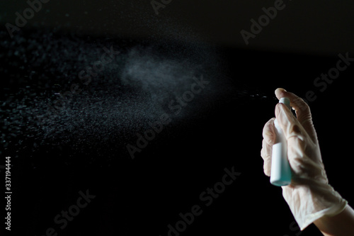 Hand using sanitizer spray  alcohol spraying disinfectant to stop spreading  coronavirus or COVID-19.