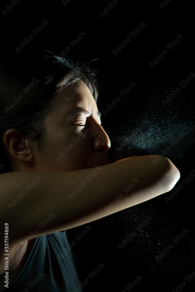 Woman coughing or sneezing in her elbow. Concept of stop spread of the virus. Spray infection Woman coughing or sneezing in her elbow. Concept of stop spread of the virus. Spray infection