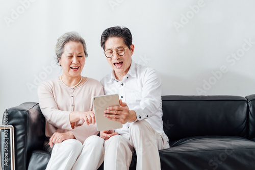 Asian aged couple using a tablet photo