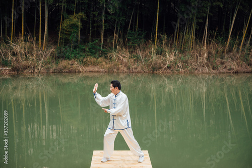 Asian aged man tai chi at the lake photo