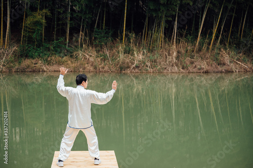 Asian aged man tai chi at the lake photo