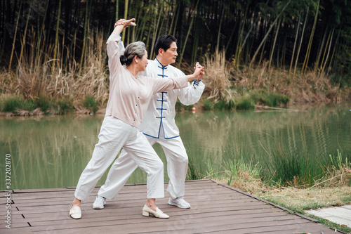 Asian aged couple tai chi in the lake