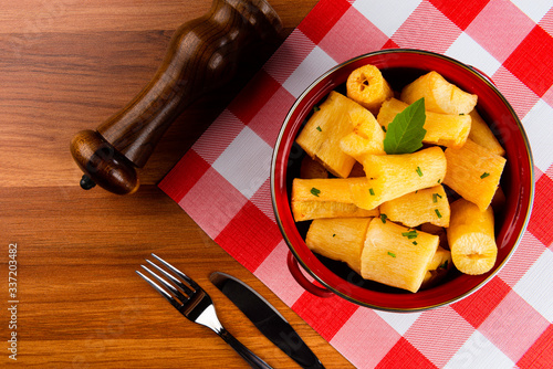 Portion of cassava fried in red pan on wooden table. photo