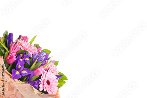 Bouquet of pink gerberas, violet irises and pink, crimson tulips in a package of paper on a white isolated background, side view. A holiday, a gift for a woman, mom, postcard, free space