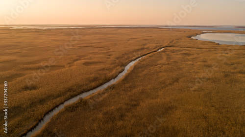 Small wild creek out of city from drone on sunset