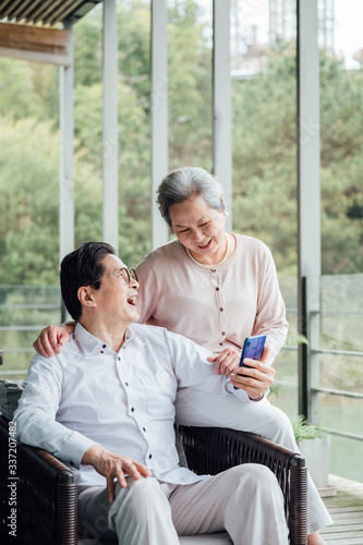 Asian aged couple using smartphone