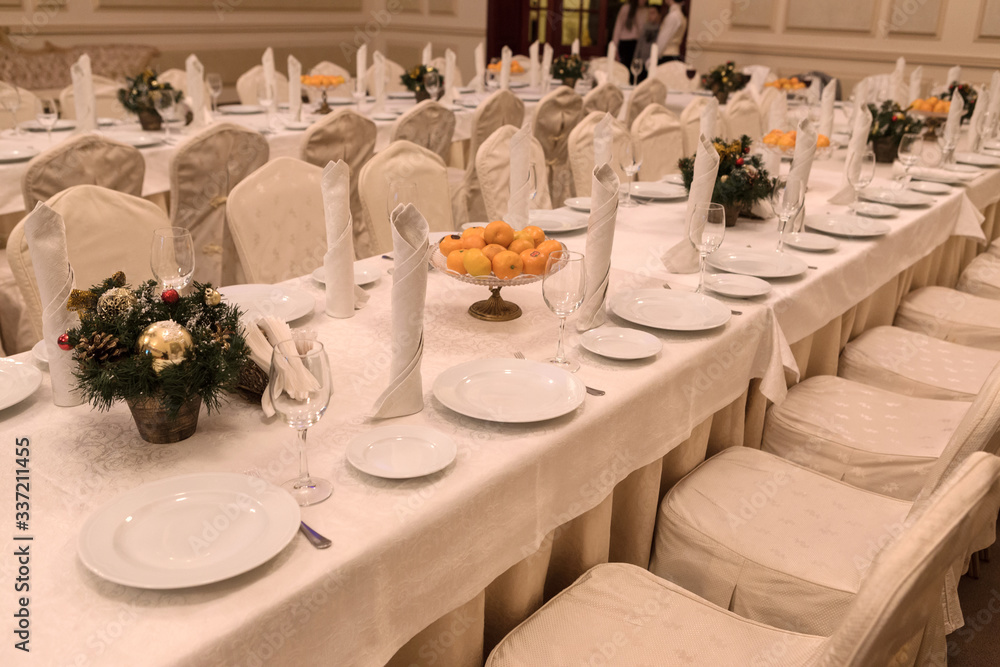 Festive table setting background. Serving a large festive restaurant table in anticipation of guests in a soft dim light.