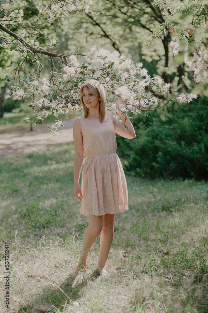Girl barefoot in a summer garden on the grass Girl barefoot in a summer garden on the grass