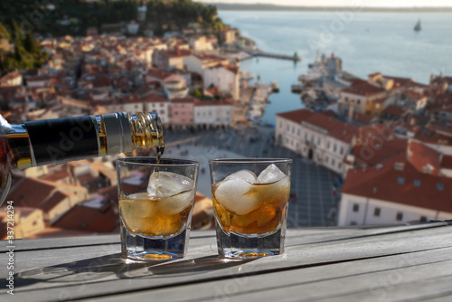 Drink for two on a terrace overlooking a small town on the Croatian coast. Two glasses of liquor for a carefree holiday concept for a couple -