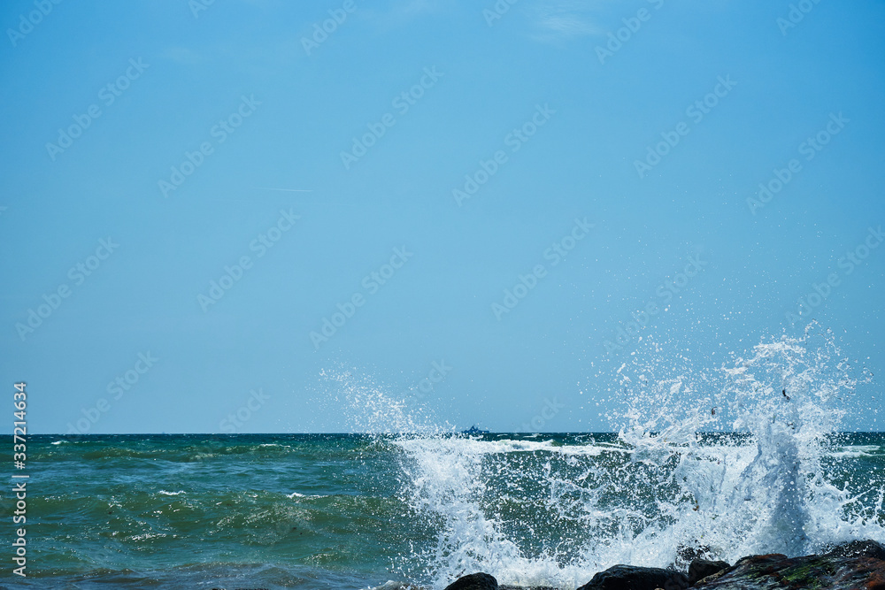 Fototapeta premium Image of the sea shore. In the background is a warship.