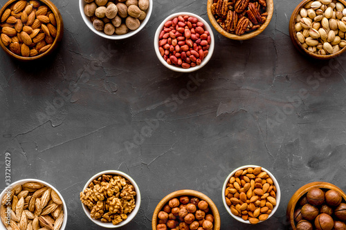 Set of macadamia, hazelnut, walnut, almond, pistachio, pecans nuts on grey background top-down frame copy space