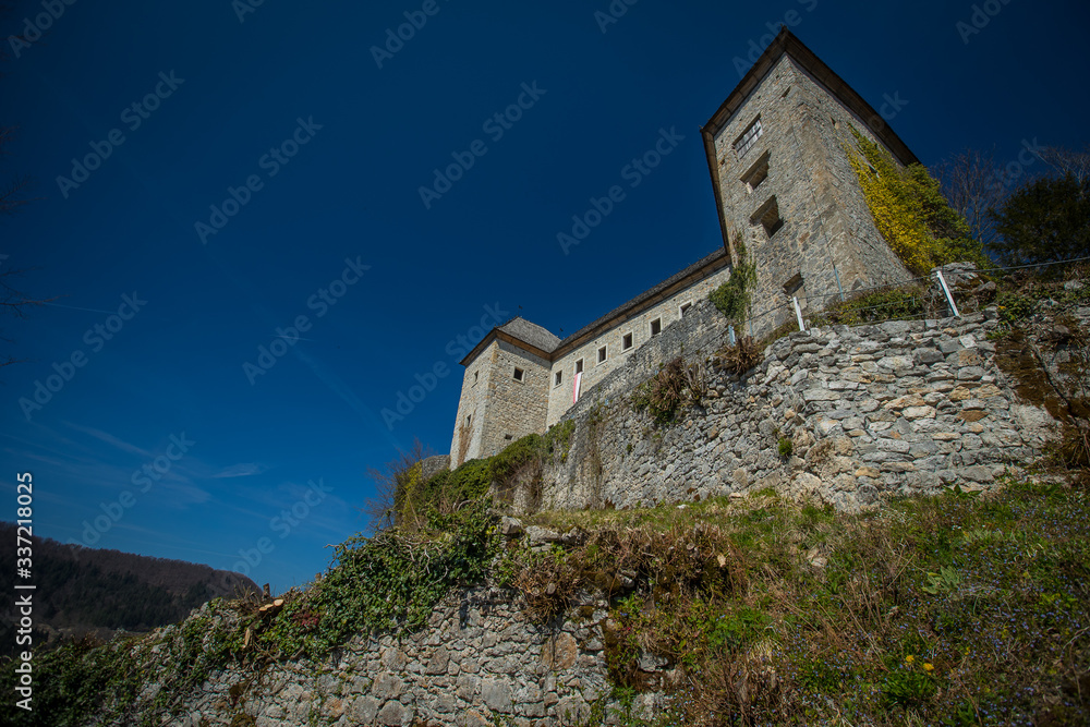 View of partially restored medieval castle of Kostel in the village of Kostel, close to Kolpa, Slovenia, on a sunny day with clear blue sky. Beautiful castle panorama.