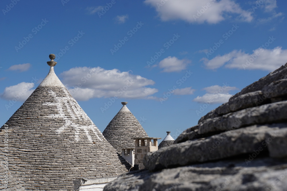 Detail of white round house with specific architecture and stone roof with sign from unesco world heritage Trulli of Alberobello in Italy