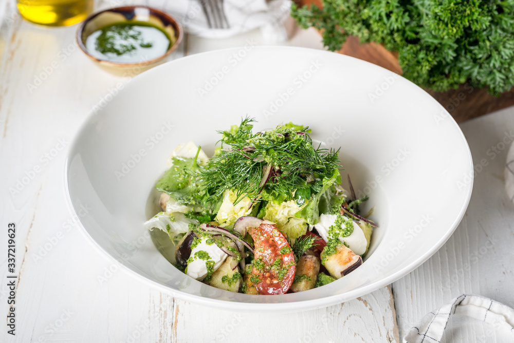 Eggplant salad with fresh herbs, served in a white plate Eggplant salad with fresh herbs, served in a white plate