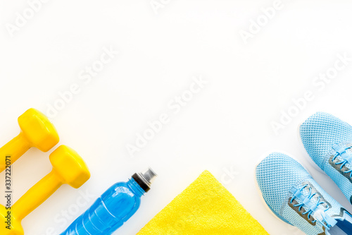 Athletics accessories. Dumbbells, towel, sneakers on white background top-down copy space