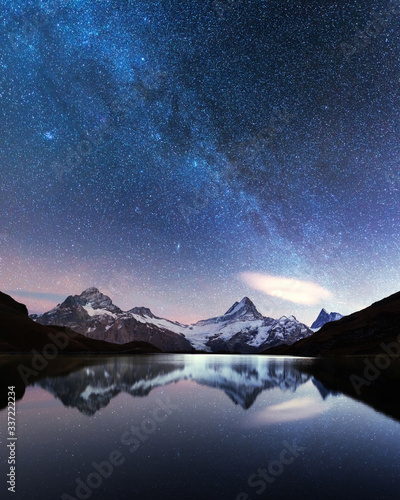 Incredible night view of Bachalpsee lake in Swiss Alps mountains. Snowy peaks of Wetterhorn, Mittelhorn and Rosenhorn on background. Grindelwald valley, Switzerland. Landscape astrophotography