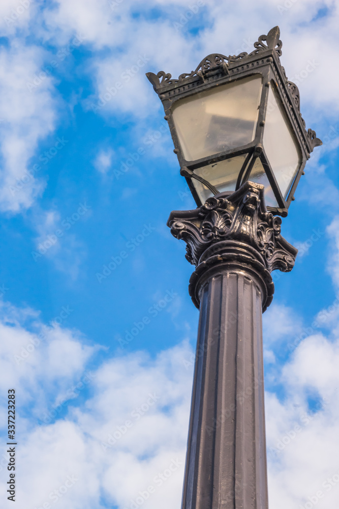 Antique French lamp post with blue sky background. 