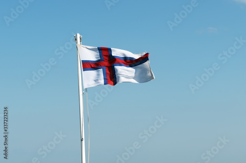Flag of Faroe islands waving against a clear blue sky photo