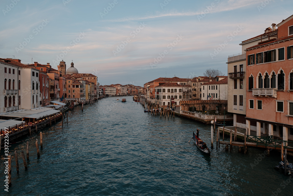 Venice, Veneto/Italy - February 16 ,2020: View over the Grand Canal in Venice and a gondola crossing the grand canal during sunset
