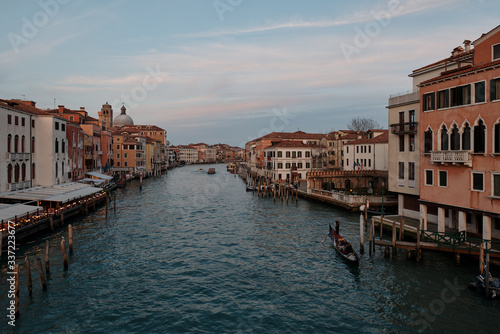 Venice, Veneto/Italy - February 16 ,2020: View over the Grand Canal in Venice and a gondola crossing the grand canal during sunset 