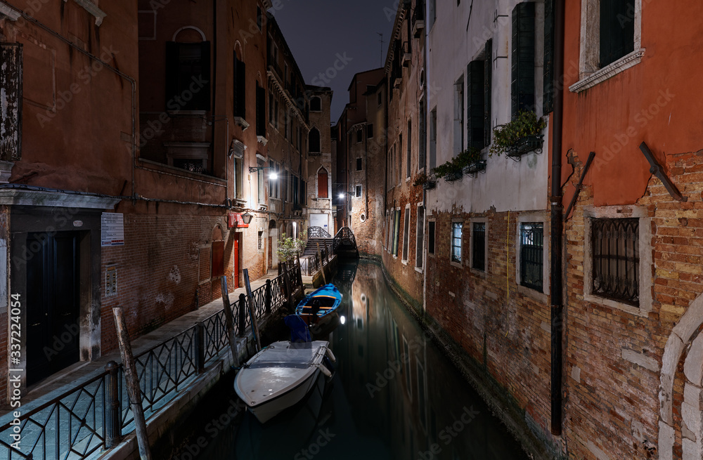 Venice, Italy - February 18, 2020: view into a small canal in Venice at night

