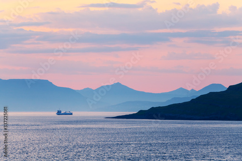 Beautiful summer sunset on Faroe Islands, Denmark. Lonely ship in the coastal waters. Landscape photography photo