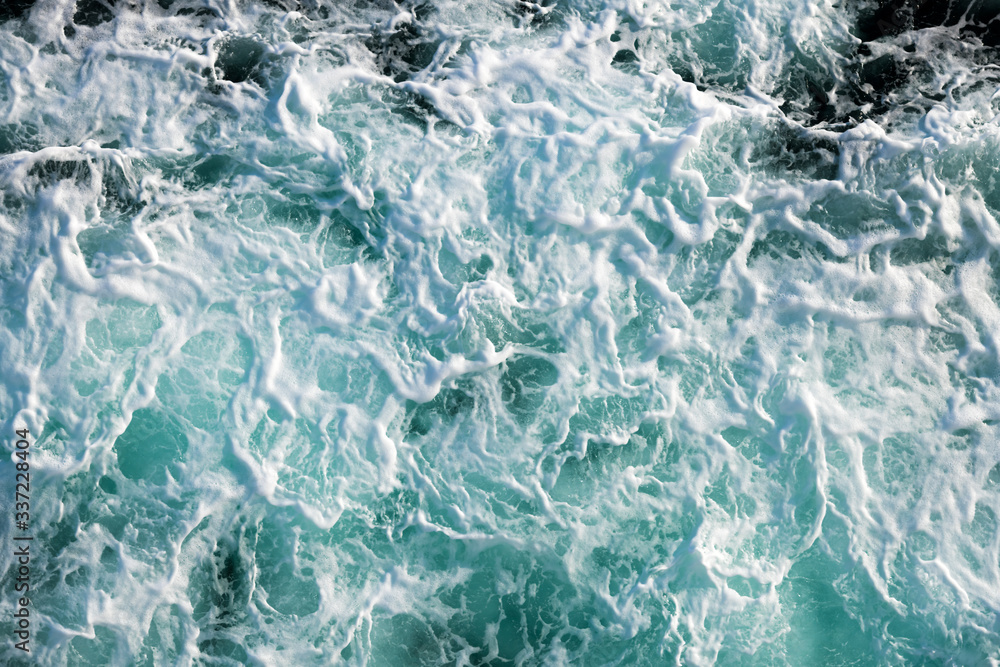 Fototapeta premium Ocean water abstract background. Sea bubbling water texture closeup