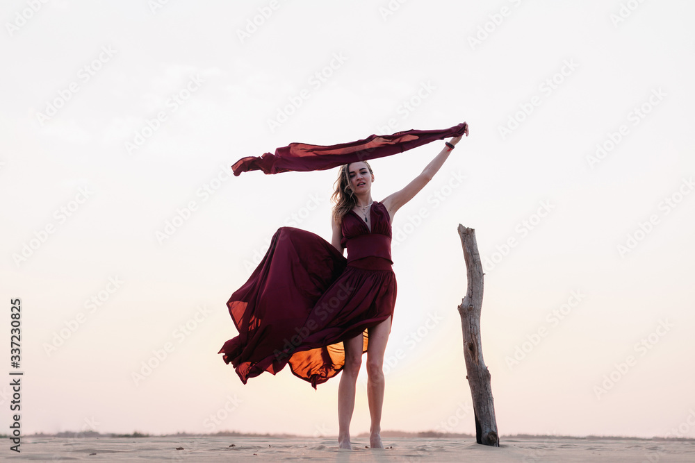 wind inflates a girl's dress in the desert