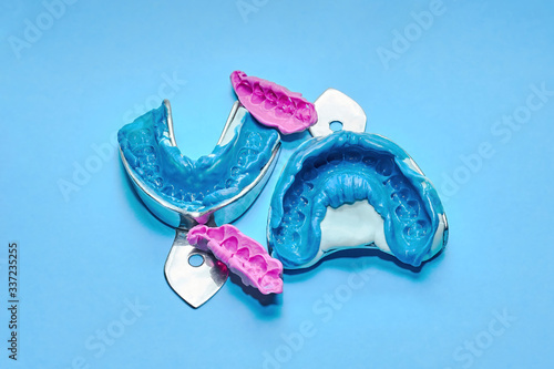 Two dental impressions on a white and blue background. The imprint of the tooth row of high precision and bite registration pieces