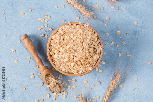 Raw oatmeal flakes on light background photo