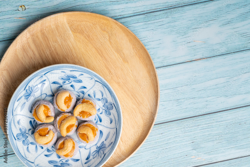 Thai Traditional Cookie on Blue Dish and Wooden Round Board with Blue Rustic Old Wooden Table Thai Traditional Cookie on Blue Dish and Wooden Round Board with Blue Rustic Old Wooden Table