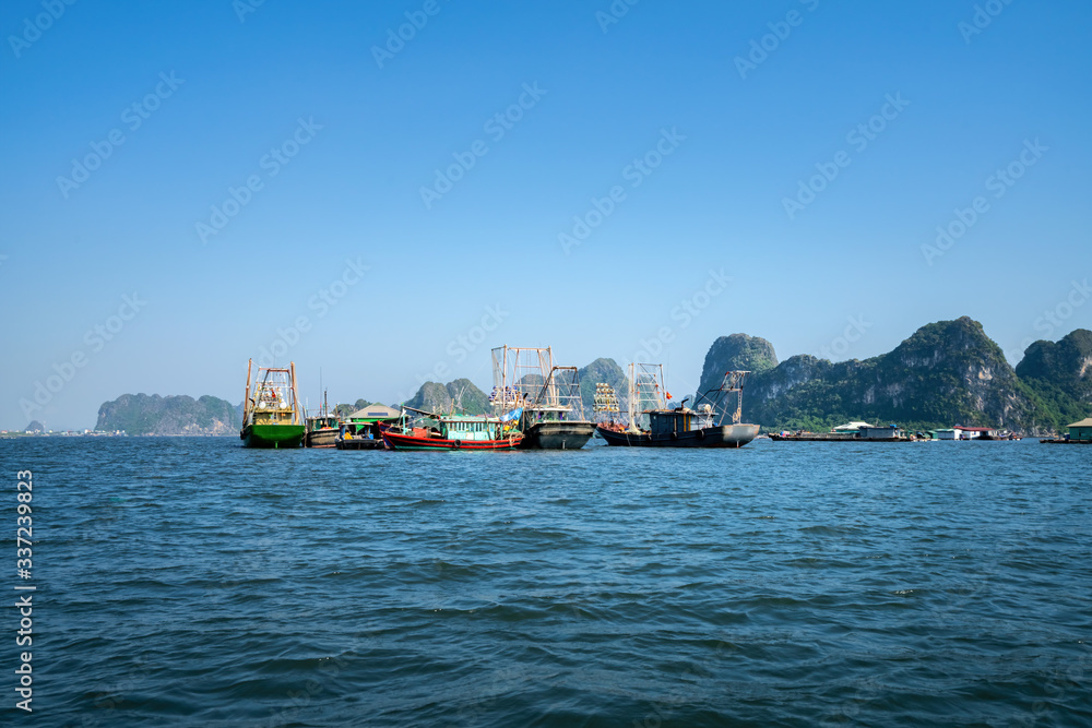Aerial view fishing village and rock island, Bai Tu Long Bay, Vietnam, Southeast Asia. UNESCO World Heritage Site. Junk boat cruise to Ha Long Bay. Popular landmark, famous destination of Vietnam