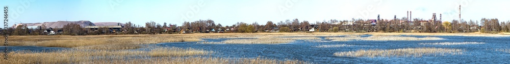 Fototapeta premium Industry and wildlife. Mining industry. The combination of nature and technology. Ore mining. The extraction of potassium salt. Belarus. Salihorsk. The mine on the background of the river.