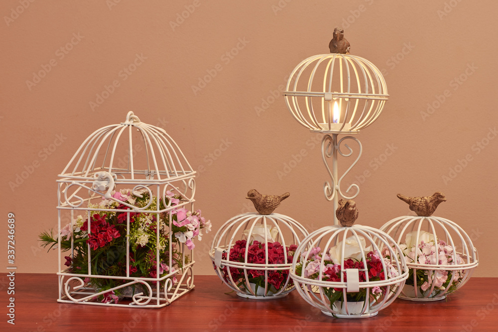 Bouquet of flowers, bird cage flower arrangement and vintage wedding decorations with burning candle