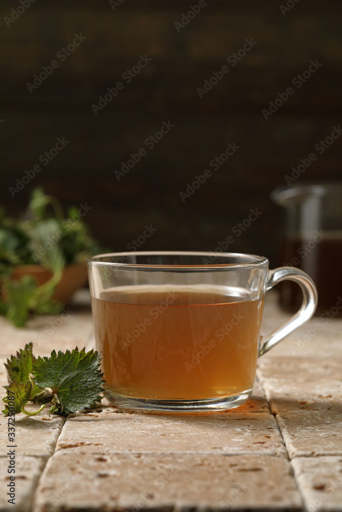 tisana o infuso di ortica in bicchiere su sfondo rustico tisana o infuso di ortica in bicchiere su sfondo rustico